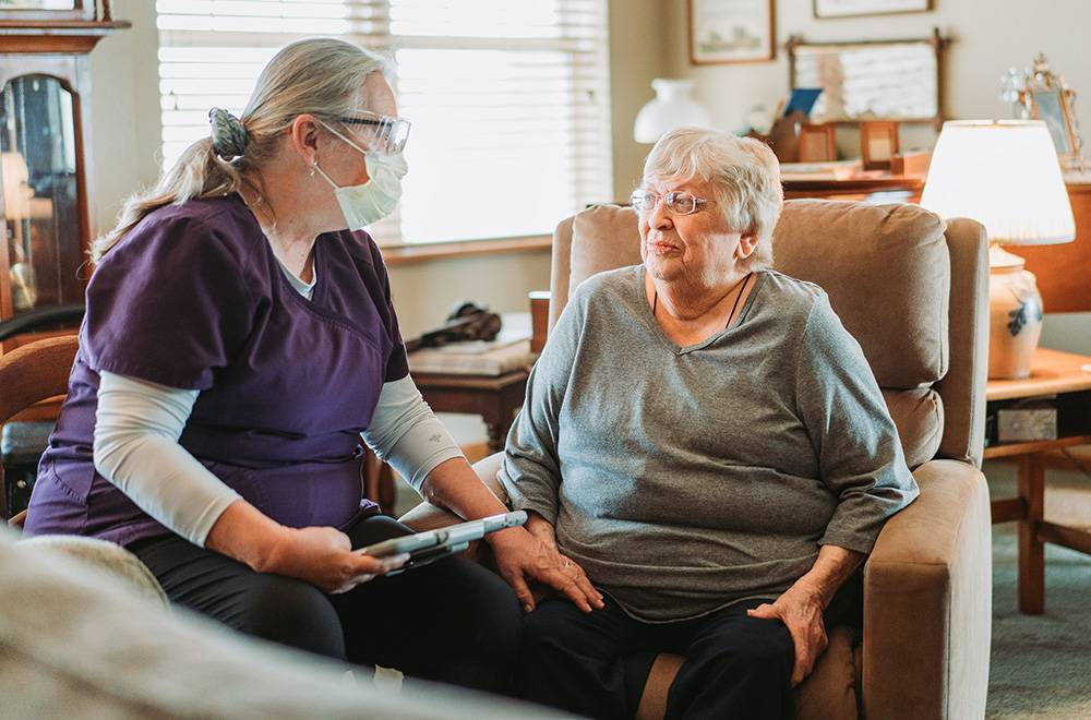 Black River homecare worker sits with a patient in her home