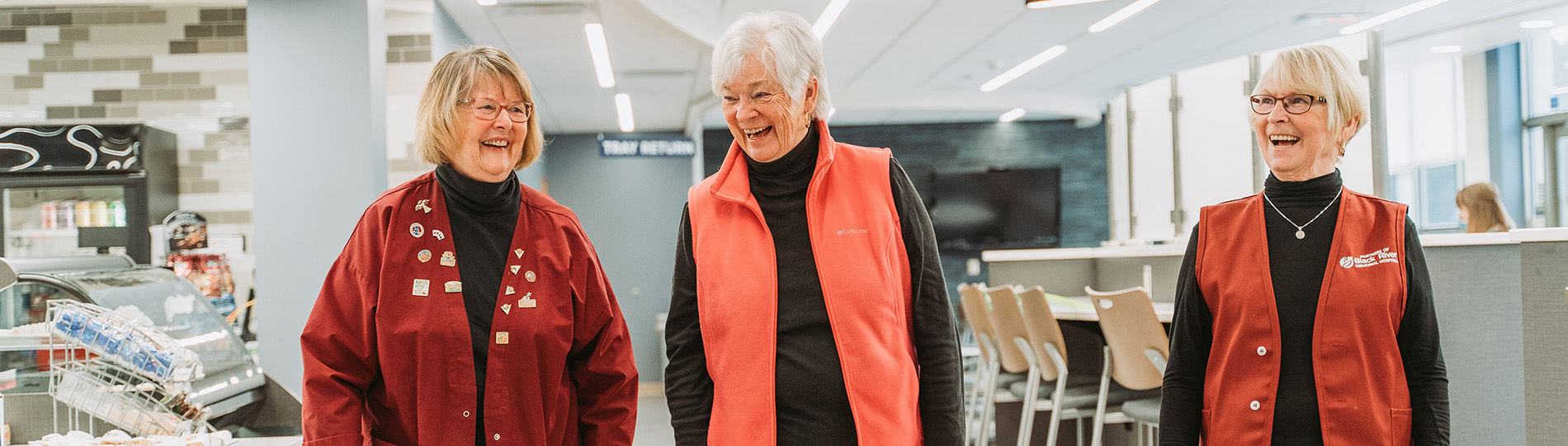 Three women who are part of the BRMH Partners volunteer program smile while walking and talking